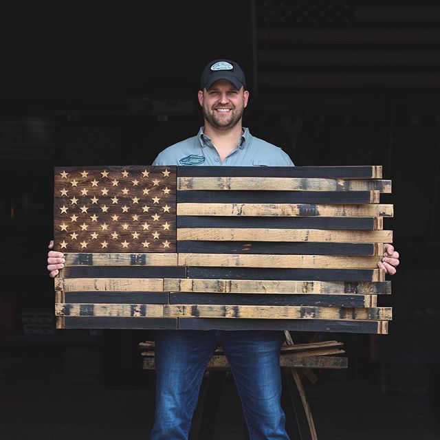 Chris Cruise holds one of his handcrafted bourbon barrel stave flags.